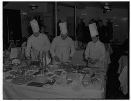 Chef Andre Fernon working on a seafood dinner with two assistants